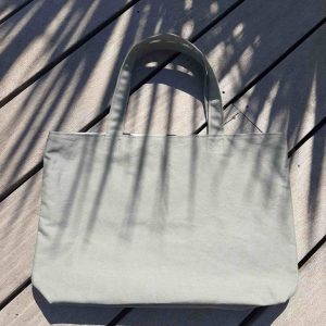 Tote bag en tissu kaki, avec anses assorties.
