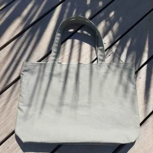 Tote bag en tissu kaki, avec anses assorties.