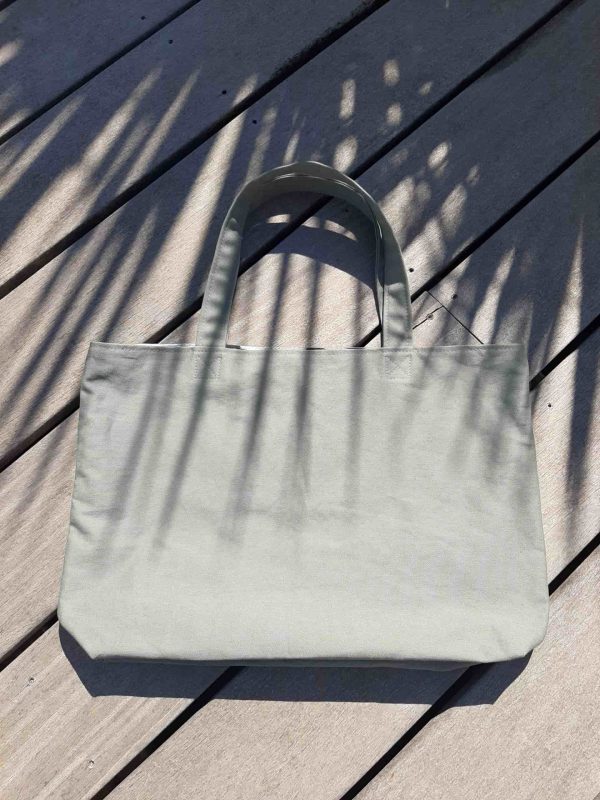 Tote bag en tissu kaki, avec anses assorties.
