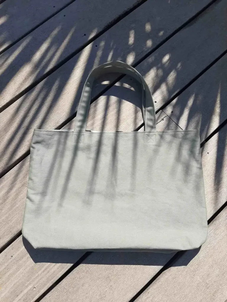 Tote bag en tissu kaki, avec anses assorties.