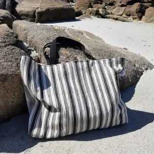 Tote bag Rayures d’Été en toile de coton écru à rayures noires, avec anses en coton, fermeture par bouton magnétique et poche plaquée intérieure.