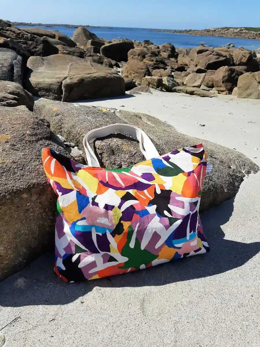 Tote bag Explosion Chromatique en toile de coton à motifs abstraits multicolores, avec anses en coton, fermeture par bouton magnétique et poche plaquée intérieure.
