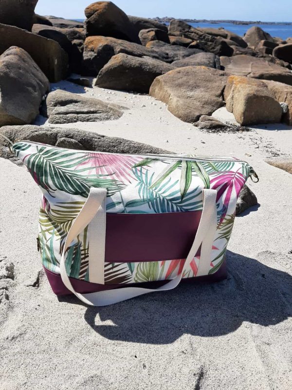 Sac Sierra vu de dos, en version ouverte avec les mousquetons défaits Le passe trolley intégré permet de le glisser sur la poignée de la valise.