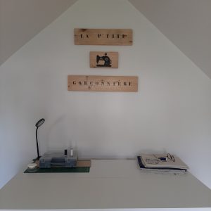 Vue de l’atelier de couture La P’tite Garçonnière avec les panneaux en bois accrochés au mur