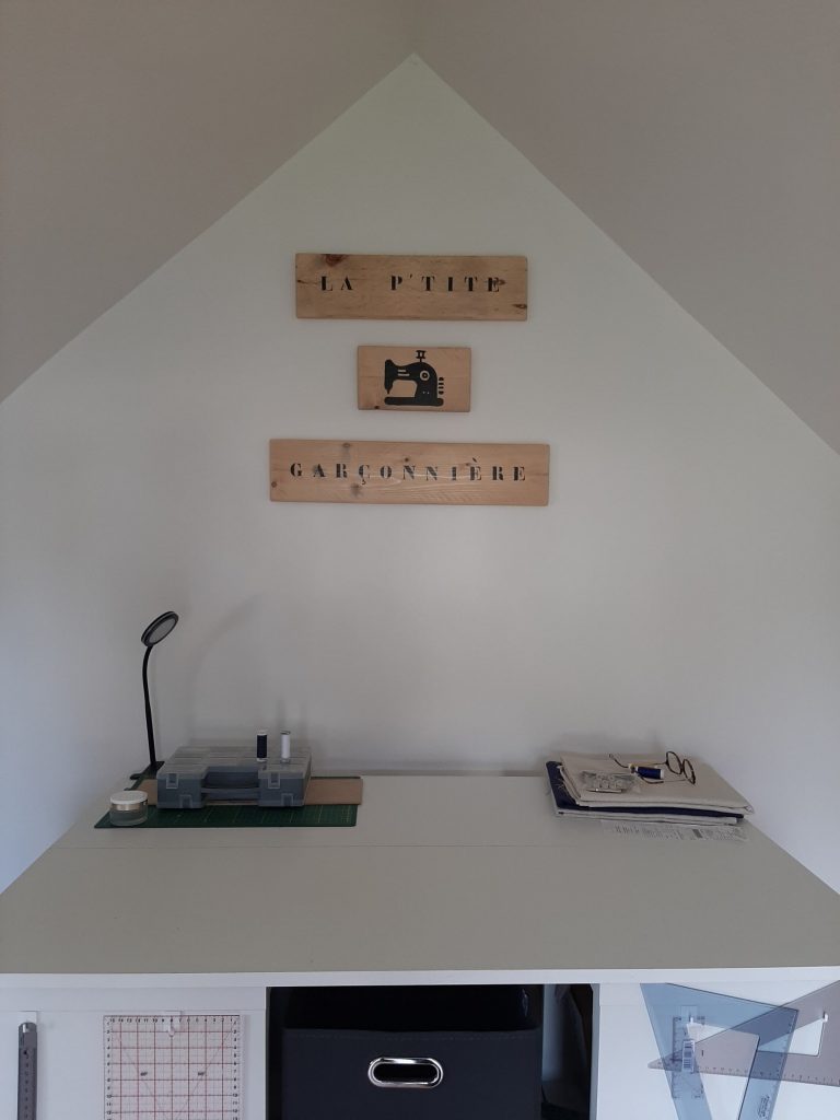 Vue de l’atelier de couture La P’tite Garçonnière avec les panneaux en bois accrochés au mur