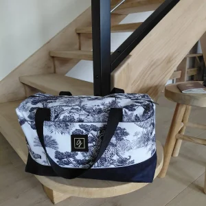 Sac week-end en toile imprimée sauvage, posé sur un escalier moderne