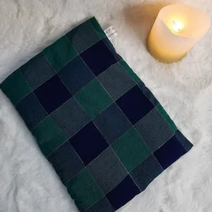 Bouillotte sèche aux grains de riz en coton motif léopard posée sur un plaid doux avec une bougie allumée – La P’tite Garçonnière