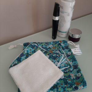 Pochon en tissu vert fleuri avec cordon de serrage, contenant 7 lingettes lavables.